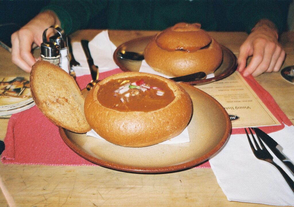 Ecco una foto del gulasch, il piatto tipico della città, inserito in una forma di pane nero.