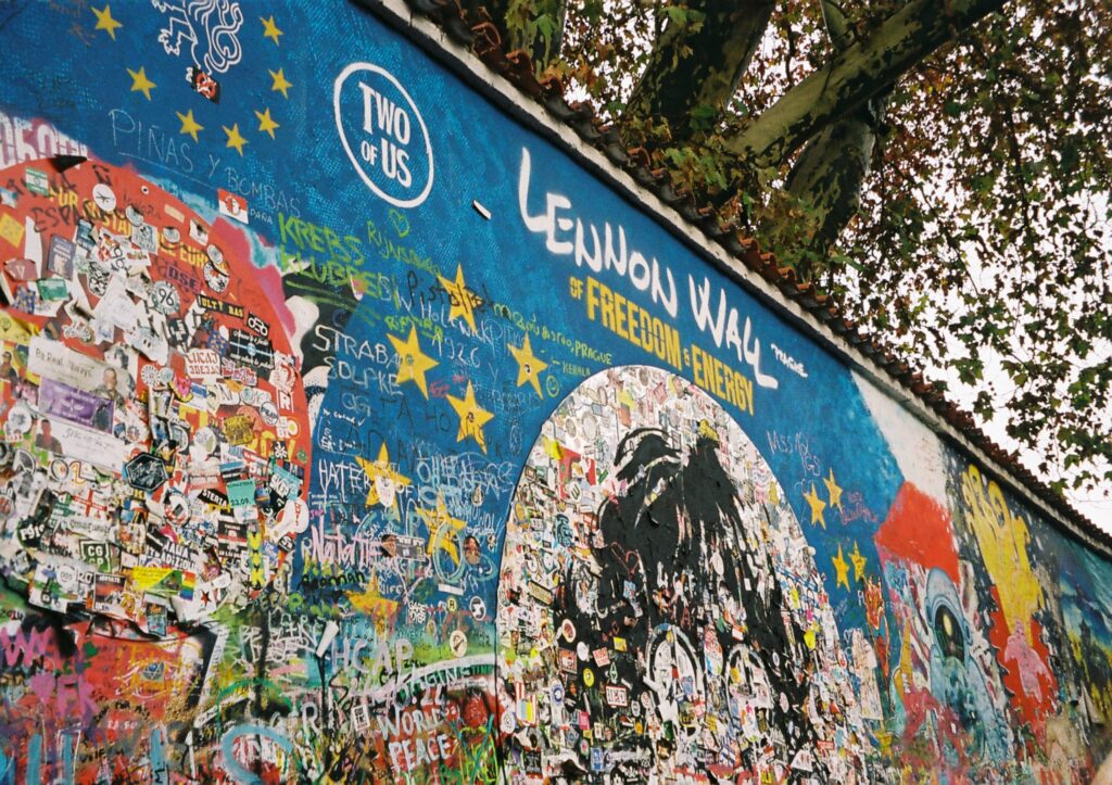 In questa foto è immortalato il muro di John Lennon, un muro blu pieno di graffiti e stickers in nome della libertà e dell'energia.